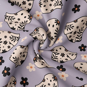 May include: Purple fabric with a repeating pattern of white and black floral designs. The design features stylised flowers and leaves.