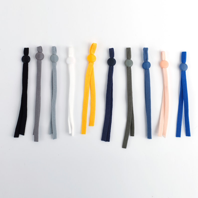 May include: Assortment of 10 colorful elastic cords with plastic stoppers. The cords are in various colors including black, gray, white, yellow, blue, and pink.