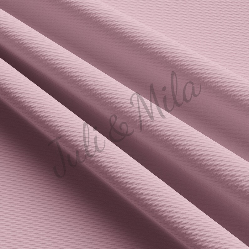 May include: A close-up of a soft, textured fabric in a dusty rose color. The fabric is folded in a way that shows the texture and the color.