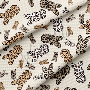 May include: A seamless pattern featuring brown and white bunny shapes with a leopard print design on a beige background.