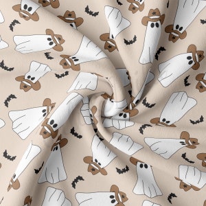 May include: A beige fabric with a repeating pattern of white ghosts wearing brown cowboy hats. Black bats are scattered throughout the fabric.