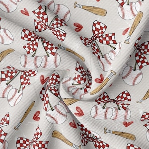 May include: A light gray fabric with a repeating pattern of baseballs, bats, red hearts, and red and white checkered bows. The baseballs are paired together, resembling cherries. The bats are brown.