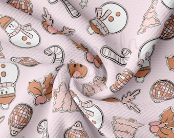 Peut inclure: Un tissu rose clair avec un motif répété d'illustrations sur le thème de Noël. Le motif comprend des bonhommes de neige, des cannes en sucre, des boules de Noël et des feuilles de houx dans des tons de blanc, marron et rose. Le tissu a un aspect texturé.