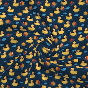 Puede incluir: Un patrón sin costuras con patos de goma amarillos flotando sobre un fondo azul oscuro. Los patos están dispuestos en un patrón de remolino, creando una sensación de movimiento. Bolas rojas y amarillas están dispersas por todo el diseño.