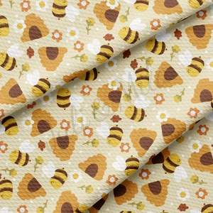May include: A seamless pattern featuring a repeating design of bees, honeycombs, and flowers in shades of yellow, brown, and white on a cream background.