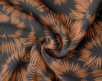 Peut inclure: Gros plan sur un tissu avec un motif tourbillonnant brun et noir. Le tissu a une surface texturée et est plié de manière à créer une impression de mouvement.