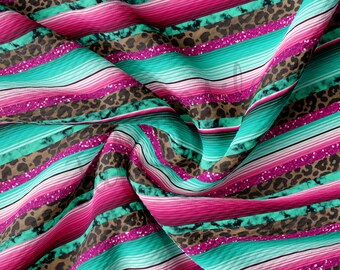 May include: A colorful fabric with pink, turquoise, and brown stripes. The fabric has a glittery texture and a leopard print pattern.