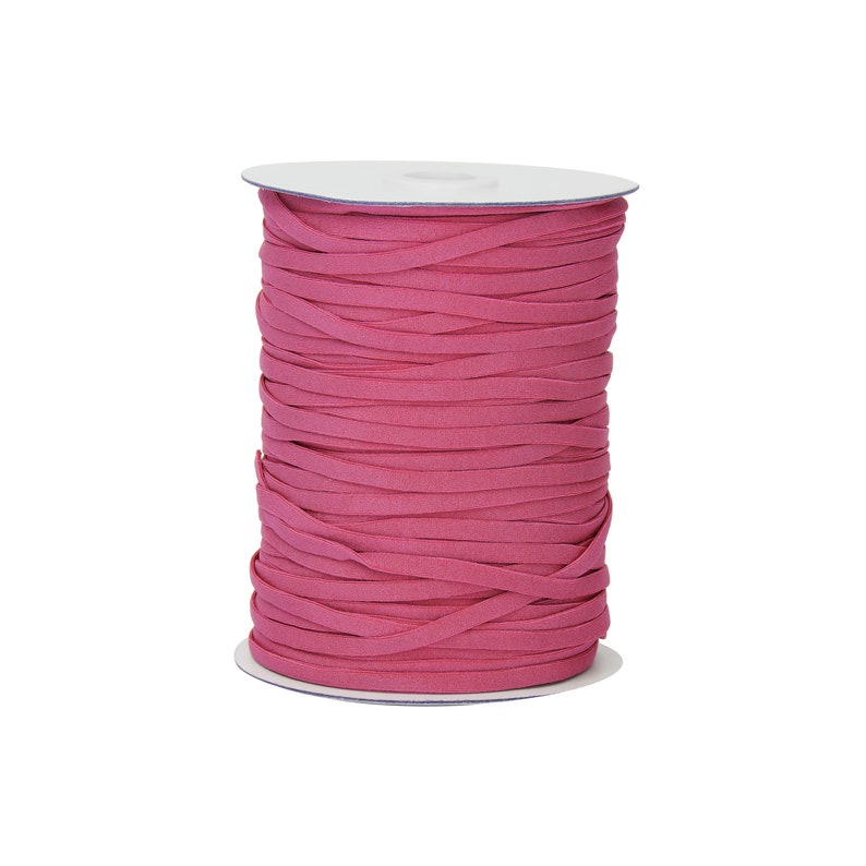 Op de afbeelding: Een spoel met roze elastisch koord, strak gewikkeld op een witte kartonnen spoel.