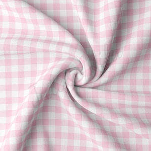 May include: Pink and white gingham fabric with a soft, textured surface. The fabric is folded and twisted, creating a swirling pattern.
