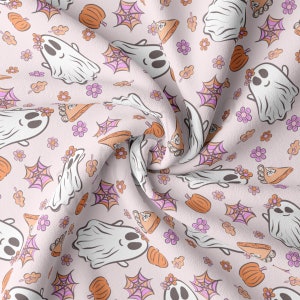 May include: A light pink fabric with a repeating pattern of smiling white ghosts, orange pumpkins, pink spiderwebs, and flowers. The ghosts have flower crowns. Autumn-themed fabric.