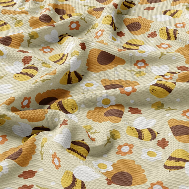 May include: A beige fabric with a repeating pattern of brown and yellow bees, sunflowers, and white flowers. The fabric has a textured waffle weave.