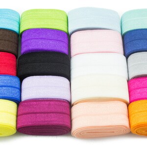 May include: A collection of 18 rolls of elastic, each in a different color. The colors include light blue, green, purple, pink, white, gray, red, black, blue, yellow, maroon, and orange.