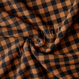 May include: A close-up of a brown and black buffalo check fabric. The fabric is textured and has a soft, cosy feel.