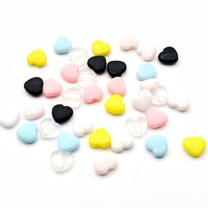 May include: Assortment of colorful heart-shaped beads in various colors, including pink, yellow, blue, black, and white. The beads are made of a soft, pliable material and have a hole in the center for stringing.