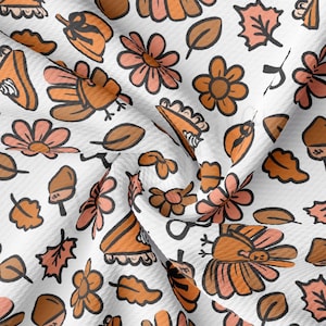 May include: A white fabric with a repeating pattern of turkeys, pie slices, flowers, leaves, and acorns. The pattern is in shades of orange, brown, and pink.