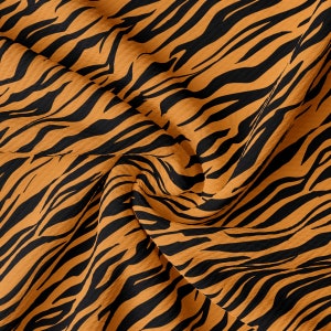May include: Orange and black tiger stripe fabric with a textured surface.