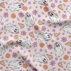 May include: A repeating pattern featuring smiling ghosts with floral crowns, pumpkins, spiderwebs, pie slices, flowers, and leaves. The design is in shades of white, orange, pink, and purple on a light pink background.