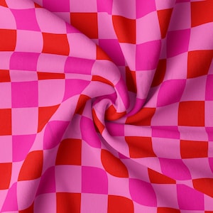 May include: Pink and red checkered fabric with a soft, crinkled texture. The fabric is folded and twisted, creating a dynamic pattern.