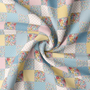 May include: A patchwork fabric with a variety of floral patterns in shades of pink, yellow, and blue. The fabric is folded and arranged in a way that shows off the different patterns.