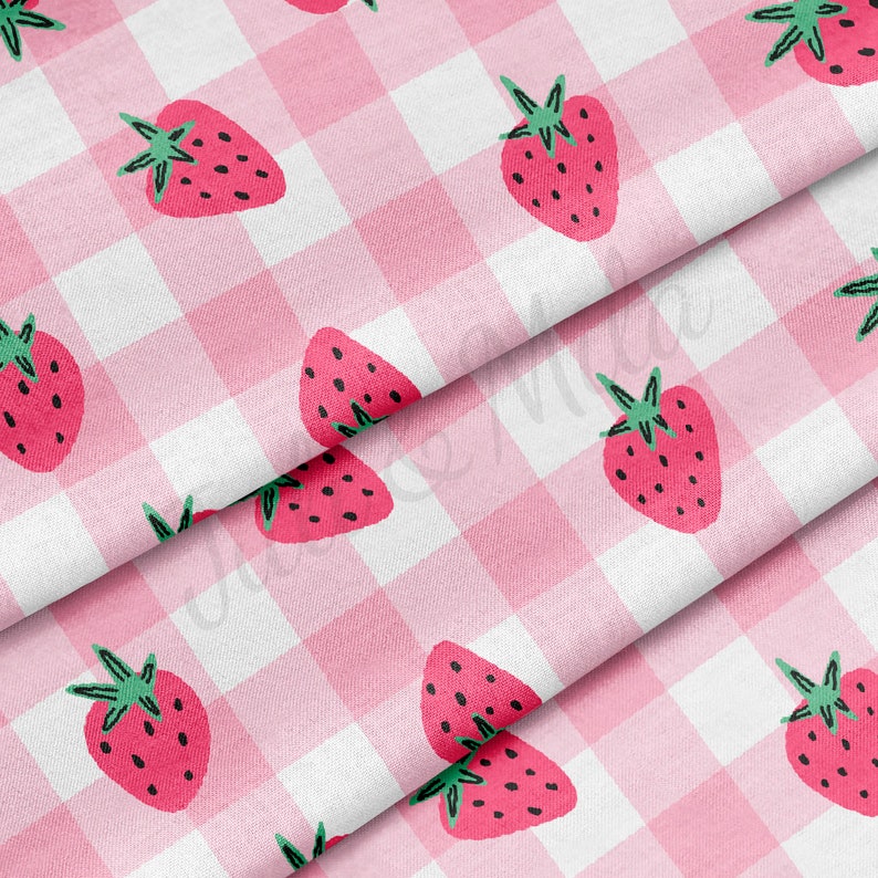 May include: Pink and white gingham fabric with a repeating pattern of red strawberries. The fabric is folded in thirds, showing the pattern from different angles.