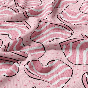 May include: A pink fabric with a repeating pattern of heart-shaped designs. Each heart has white and pink stripes, outlined in black. The background is a lighter pink with small, scattered pink dots.