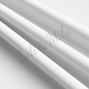 Pode incluir: Tecido branco com textura lisa, dobrado em uma série de curvas suaves. O tecido é um material leve e arejado, perfeito para drapeados ou para criar um fundo.