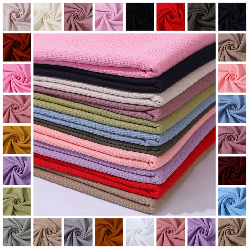 May include: A stack of 20 waffle knit fabric swatches in various colors, including pink, red, blue, green, brown, and beige. The fabric is soft and textured, and it would be perfect for making clothing, blankets, or other crafts.