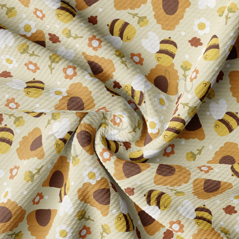 May include: A beige fabric with a repeating pattern of yellow bees, brown sunflowers, and white daisies. The fabric is textured and has a waffle-like appearance.