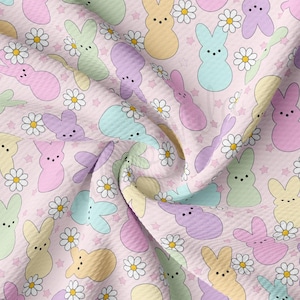 May include: A pink fabric with a repeating pattern of pastel-colored bunny-shaped marshmallow candies and white daisies.