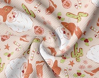 Peut inclure: Un tissu beige avec un motif répété de Père Noël, de cannes en sucre, d'étoiles et de cactus. Le tissu a une texture en nid d'abeille.