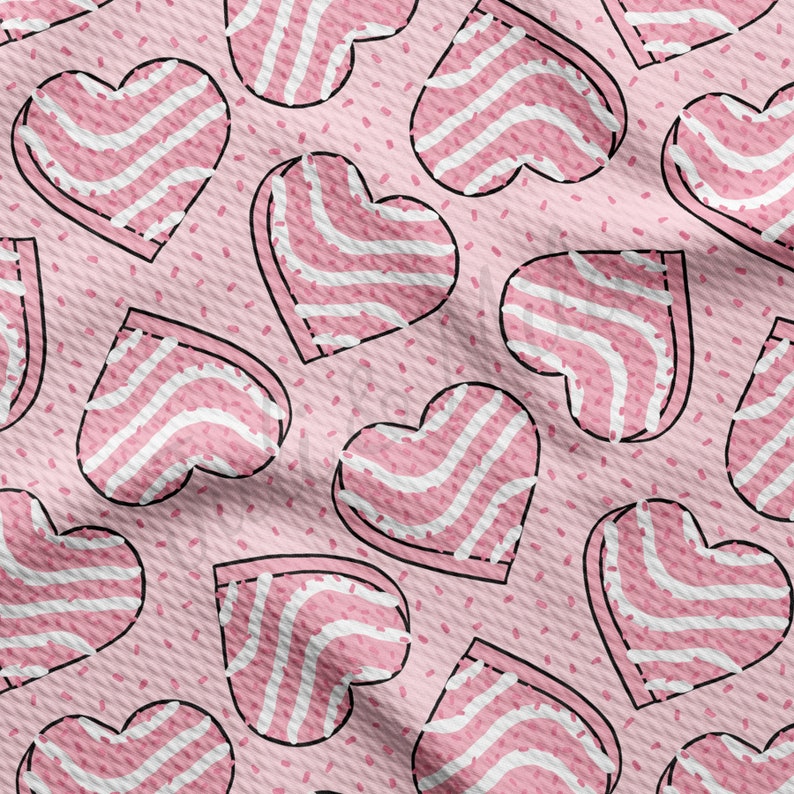 May include: A repeating pattern of pink hearts with white striped designs and black outlines. The hearts are scattered across a light pink background with small, scattered red dots. The overall design has a fabric-like texture.