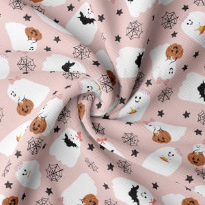 May include: Pink fabric with a repeating pattern of white ghosts holding orange pumpkins, black bats, and spiderwebs. The fabric has a slightly textured surface.