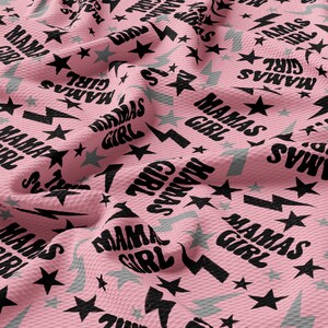 a pink fabric with black stars on it