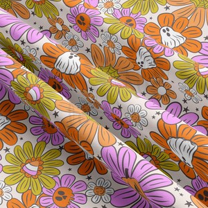 May include: A seamless pattern featuring a variety of colorful flowers with Halloween-themed details, including candy corn, ghosts, and skulls. The background is a light beige color.