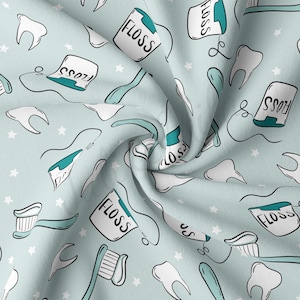 May include: A light blue fabric with a repeating pattern of white teeth, toothbrushes, floss containers, and stars. The floss containers have the word "FLOSS" written on them.