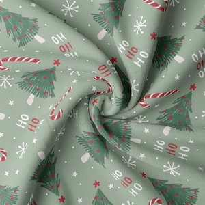 May include: Green fabric with a repeating pattern of Christmas trees, candy canes, snowflakes, and the words "Ho Ho Ho".