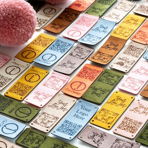 May include: Assortment of colorful leather labels with various designs, including a QR code, text that says "Your Logo Here", and the words "Cut Design".