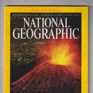 May include: A National Geographic magazine cover from February 2002, featuring a fiery volcano eruption. The cover has a yellow border and the title "Etna Ignites." Additional text includes article titles and the magazine's website.
