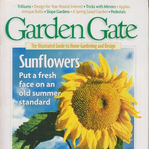 May include: A magazine cover featuring a large, bright yellow sunflower with a blue sky and white clouds in the background. The magazine is titled "Garden Gate: The Illustrated Guide to Home Gardening and Design." The cover text reads "Sunflowers: Put a fresh face on an old summer standard." The magazine is dated April 1999, Issue No. 26.