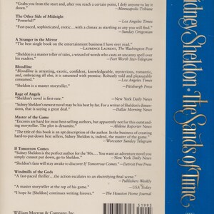 Puede incluir: Contraportada del libro "Sidney Sheldon: The Sands of Time". La cubierta es azul con texto blanco, incluyendo el t&iacute;tulo y el nombre del autor. Presenta citas de cr&iacute;ticos elogiando la obra del autor.