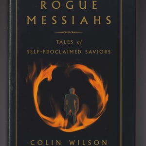 May include: A book cover for "Rogue Messiahs" by Colin Wilson. The cover is black with gold lettering and a gold border. The title and author's name are in gold. A fiery orange ring surrounds a silhouetted figure.