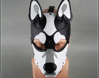 May include: A black and white leather dog mask with gray ears and a black nose. The mask has a strap that goes around the head and is designed to fit over the eyes.