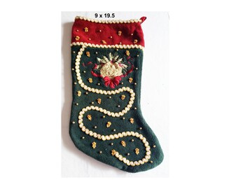 Puede incluir: Un calcetín navideño, de aproximadamente 23 x 49,5 cm, en verde oscuro con un puño rojo. El calcetín está decorado con detalles de cuentas blancas y doradas y un diseño bordado con una campana y un lazo.