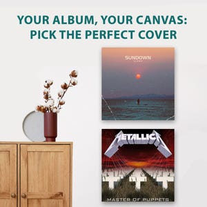 May include: A wooden cabinet with two doors, a dark red fluted vase containing cotton stems, and two square canvas prints. The top print shows a sunset over water with the text SUNDOWN SLOWM. The bottom print shows the Metallica Master of Puppets album cover.
