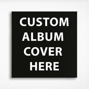 May include: A square, black canvas with the words "CUSTOM ALBUM COVER HERE" in large, white, sans-serif font. The text is centered and stacked vertically, creating a bold and simple design.
