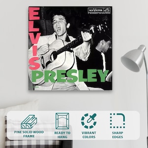 May include: A square wall art print featuring a black and white photograph of Elvis Presley playing an acoustic guitar. The name ELVIS is printed in large pink vertical letters on the left, and PRESLEY is in large green letters at the bottom.