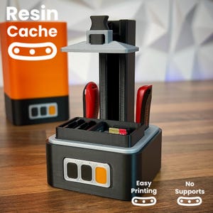 May include: A black and gray 3D printer with a rectangular base and a vertical support structure. The printer has a small tray with storage for SD cards and USB drives. The words "Resin Cache", "Easy Printing", and "No Supports" are visible.