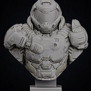 May include: A gray, detailed bust of a video game character wearing a helmet with a visor. The character is wearing armor with a variety of textures and details. The bust is mounted on a gray base.