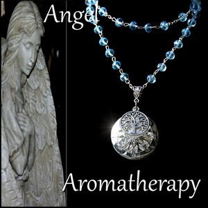 May include: A silver necklace with a tree of life pendant and blue glass beads. The necklace is on a black background with the words "Angel" and "Aromatherapy" written in white.