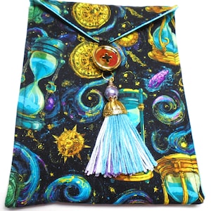 May include: A fabric pouch featuring a black background with a pattern of gold clocks, blue hourglasses, and swirling cosmic designs. The pouch has a triangular flap secured by a large gold button with a dangling light blue and purple tassel.